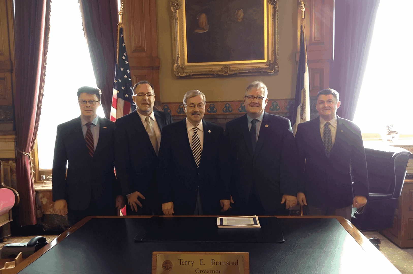 Five men standing in an official office.